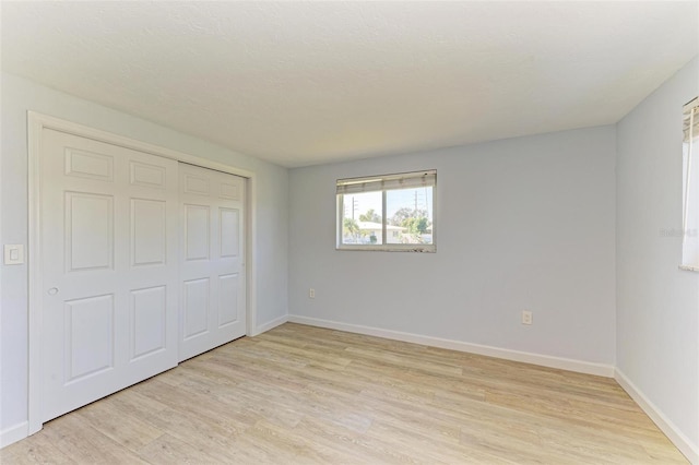 unfurnished bedroom featuring light hardwood / wood-style floors and a closet