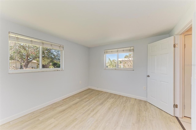 empty room with light wood-type flooring and a wealth of natural light