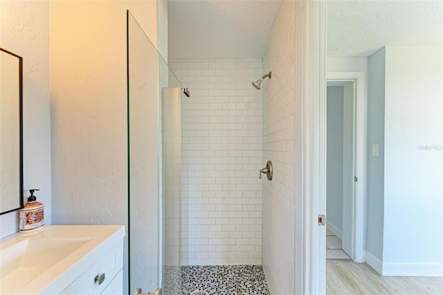 bathroom featuring a tile shower, vanity, a textured ceiling, and hardwood / wood-style flooring