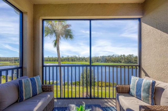 sunroom featuring a water view