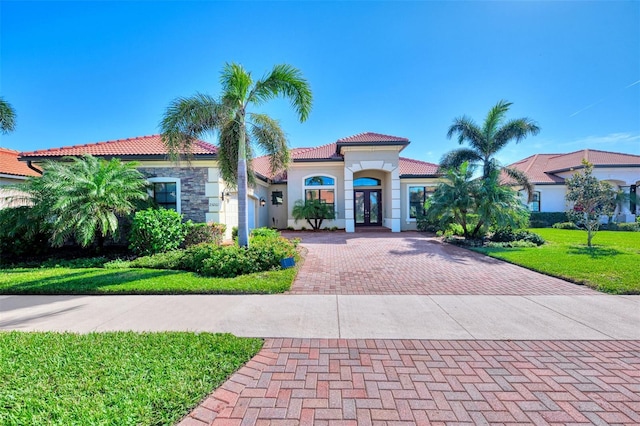 mediterranean / spanish home featuring french doors and a front yard