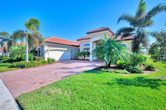 mediterranean / spanish home featuring a garage and a front lawn