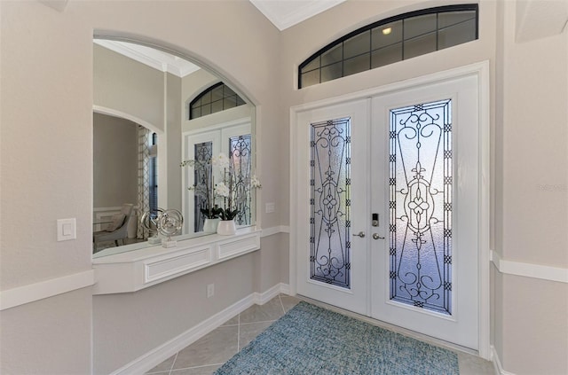 foyer entrance with french doors, crown molding, and light tile patterned flooring