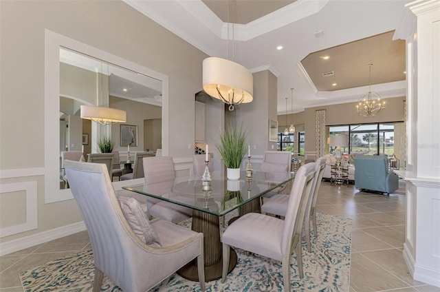 dining space featuring a tray ceiling, crown molding, light tile patterned floors, and an inviting chandelier