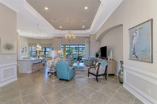 living room featuring a raised ceiling, crown molding, light tile patterned floors, and a notable chandelier