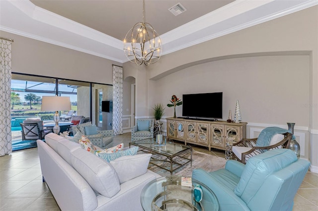 tiled living room with a raised ceiling, crown molding, and a notable chandelier