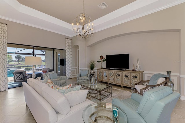 tiled living room featuring crown molding, a tray ceiling, and a chandelier