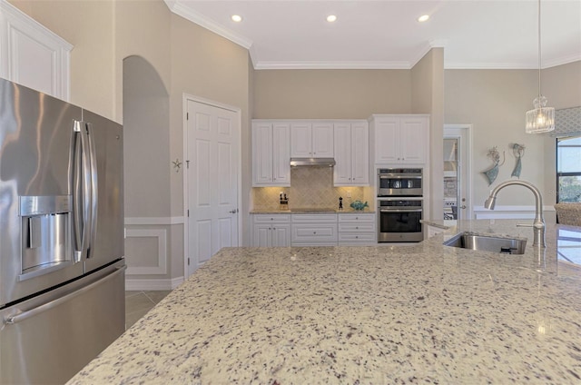 kitchen with white cabinetry, sink, light stone counters, decorative light fixtures, and appliances with stainless steel finishes