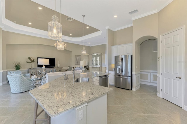 kitchen featuring sink, white cabinetry, stainless steel appliances, and a large island with sink