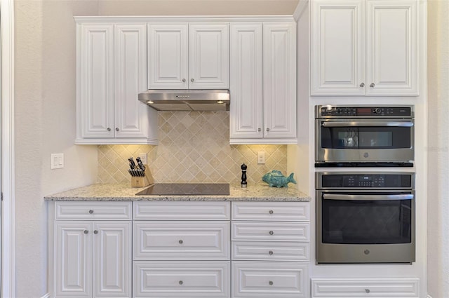 kitchen featuring light stone countertops, decorative backsplash, white cabinetry, and stainless steel double oven