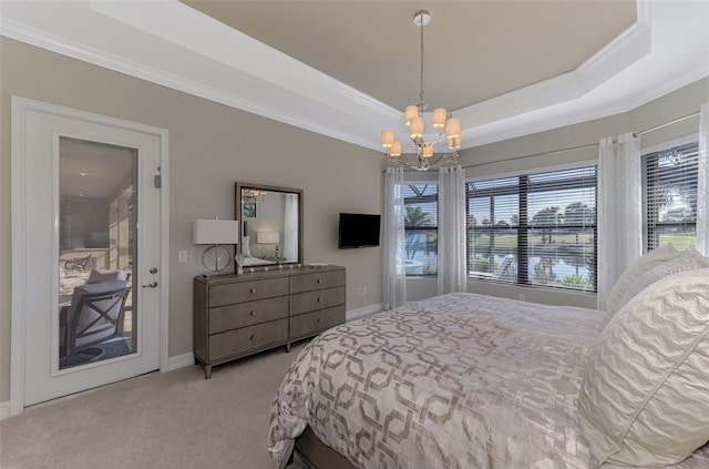 carpeted bedroom with access to exterior, a tray ceiling, an inviting chandelier, and ornamental molding