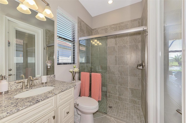 bathroom featuring tile patterned floors, vanity, an enclosed shower, and toilet