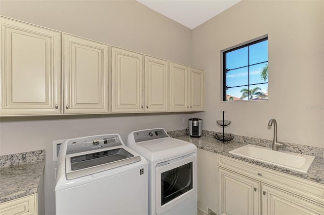 clothes washing area with cabinets, washing machine and dryer, and sink