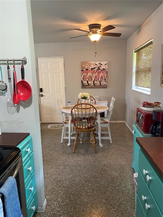 dining area featuring dark colored carpet and ceiling fan