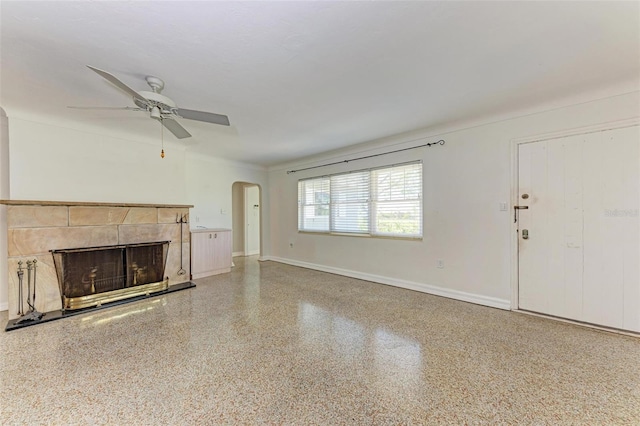 unfurnished living room featuring ceiling fan and a fireplace