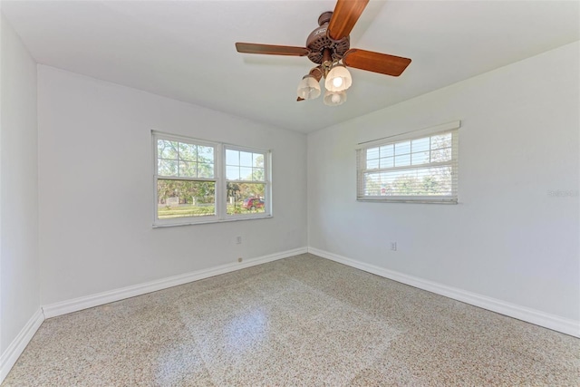 empty room featuring plenty of natural light and ceiling fan