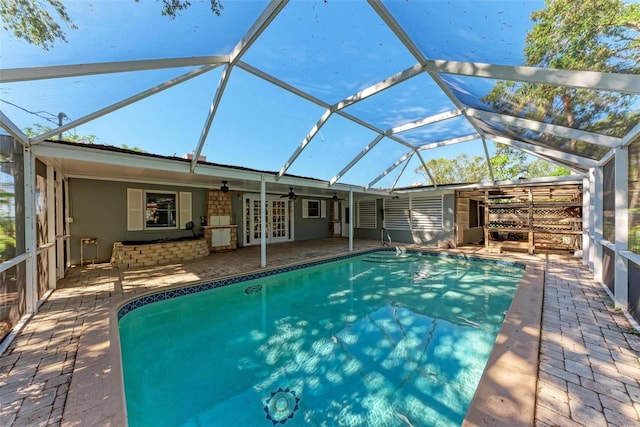 view of swimming pool with ceiling fan, a lanai, a patio, and french doors