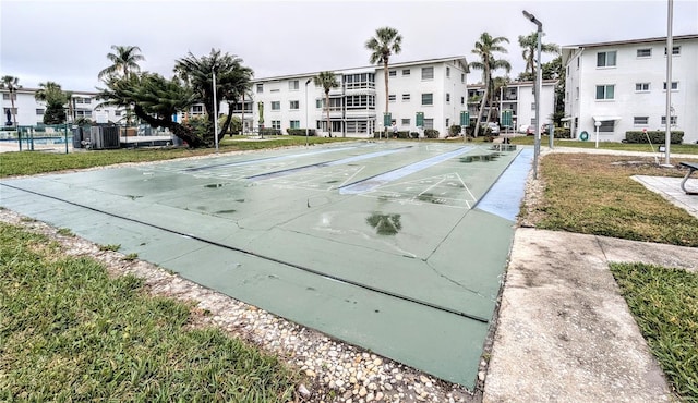 view of community featuring fence and shuffleboard