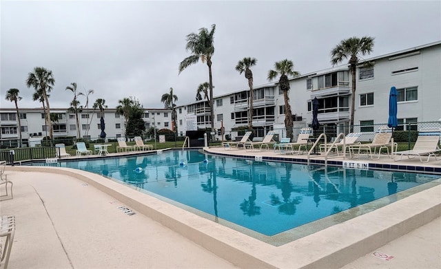 pool with a patio area and fence