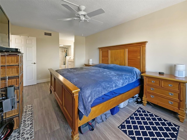 bedroom featuring a textured ceiling, dark hardwood / wood-style floors, and ceiling fan