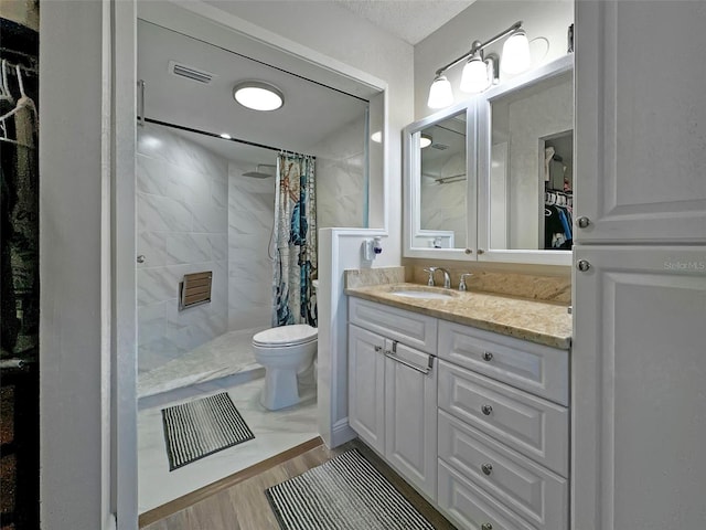 bathroom with vanity, hardwood / wood-style flooring, toilet, and curtained shower