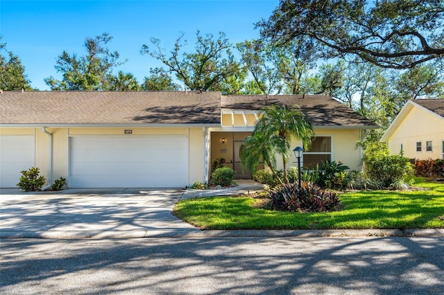 ranch-style house featuring a front yard and a garage