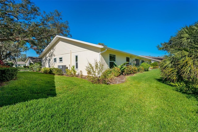 view of side of home with a lawn and central air condition unit