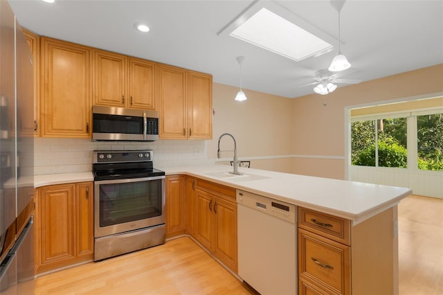 kitchen featuring kitchen peninsula, light wood-type flooring, and stainless steel appliances