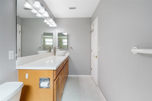 bathroom with tile patterned flooring, vanity, and toilet