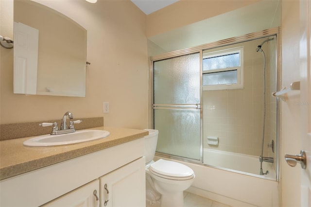 full bathroom featuring tile patterned floors, vanity, bath / shower combo with glass door, and toilet