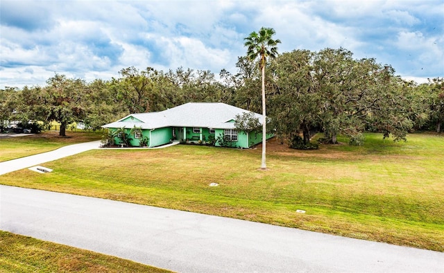 view of front facade with concrete driveway and a front yard