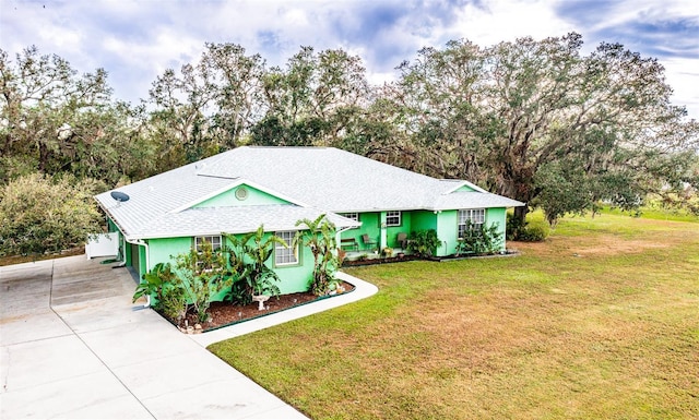 single story home with concrete driveway and a front yard