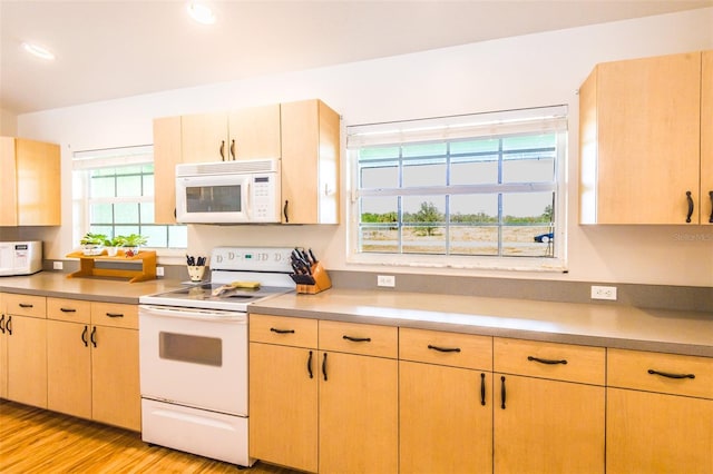 kitchen featuring light countertops, white appliances, and light brown cabinets