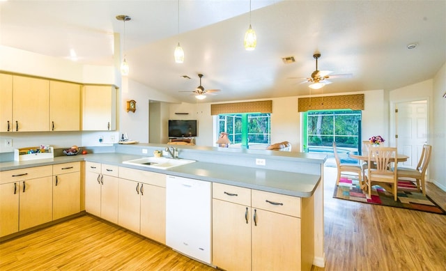 kitchen featuring a peninsula, white dishwasher, light countertops, and decorative light fixtures