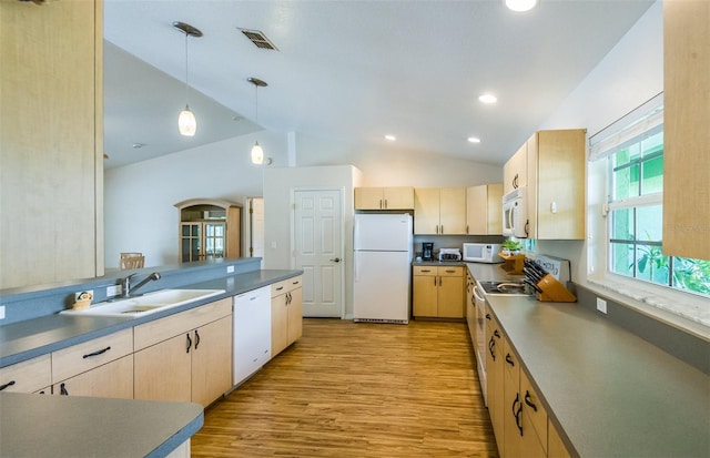 kitchen featuring pendant lighting, dark countertops, light brown cabinets, a sink, and white appliances