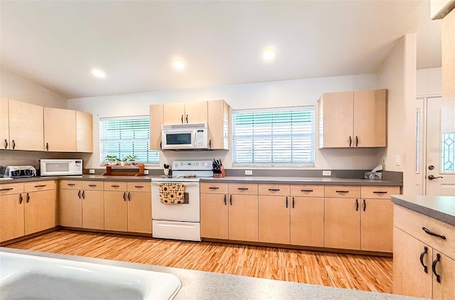 kitchen with white appliances, dark countertops, light brown cabinetry, light wood-type flooring, and recessed lighting