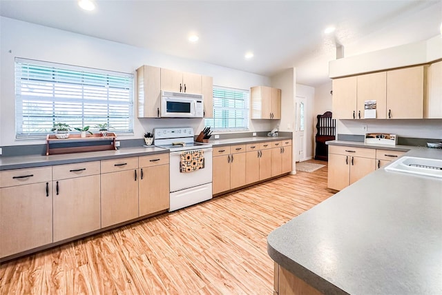 kitchen with recessed lighting, white appliances, a sink, and light wood finished floors