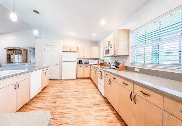 kitchen with white appliances, lofted ceiling, hanging light fixtures, light countertops, and a sink