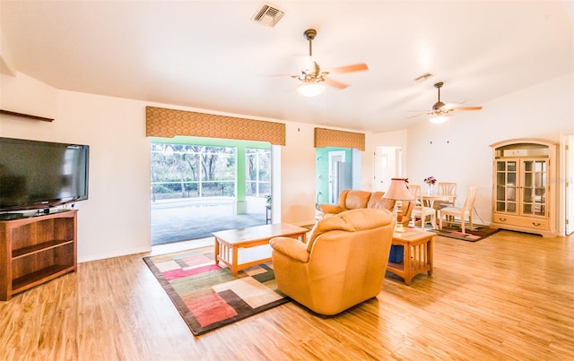 living room with baseboards, wood finished floors, visible vents, and a ceiling fan