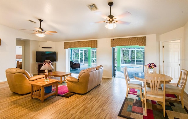 living area with a healthy amount of sunlight, light wood-style floors, and visible vents