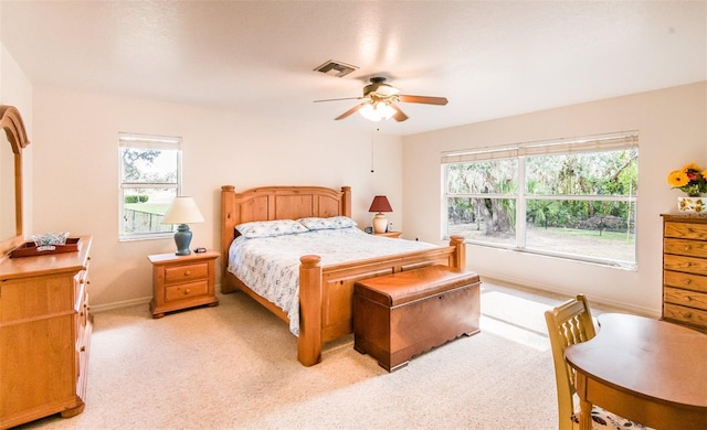 bedroom featuring light carpet, ceiling fan, visible vents, and baseboards