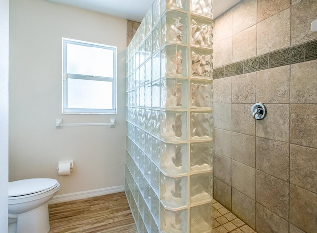 full bath featuring toilet, baseboards, walk in shower, and wood finished floors