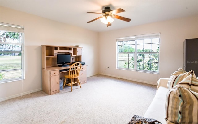 office area featuring a ceiling fan, light colored carpet, and baseboards