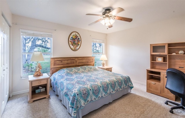 bedroom featuring multiple windows, baseboards, and light colored carpet