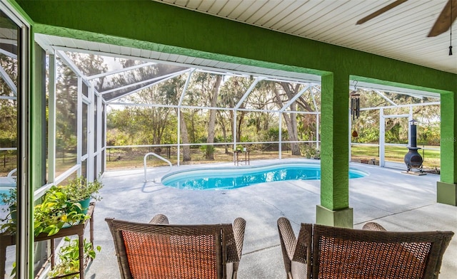 outdoor pool with a lanai, a patio, and ceiling fan