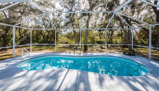 pool featuring glass enclosure and a patio