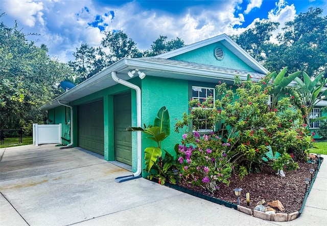 1496 Palm View Rd, Sarasota, FL 34240 - view of side of property with stucco siding, driveway, and a garage