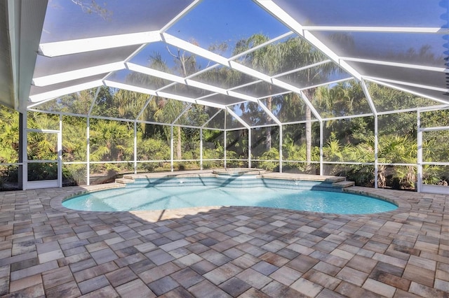 view of swimming pool with glass enclosure and a patio area