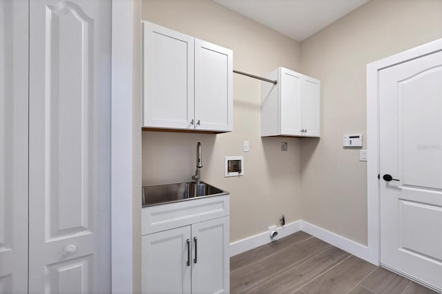 washroom with cabinets, hookup for a washing machine, electric dryer hookup, sink, and light hardwood / wood-style flooring