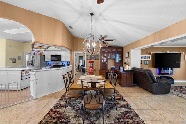 tiled dining space with ceiling fan with notable chandelier and vaulted ceiling